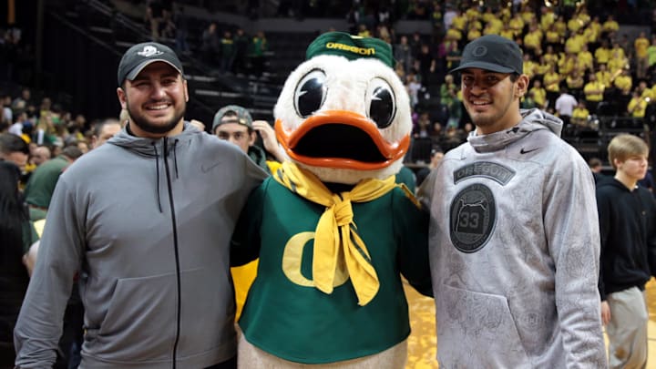 Once a Duck, always a Duck: Hroniss Grasu and Marcus Mariota pose with the best mascot in sports at a basketball game in 2016.