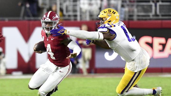 Nov 4, 2023; Tuscaloosa, Alabama, USA;  Alabama Crimson Tide quarterback Jalen Milroe (4) runs against LSU Tigers defensive end Bradyn Swinson (13) at Bryant-Denny Stadium. Alabama defeated LSU 42-28. Mandatory Credit: Gary Cosby Jr.-Imagn Images