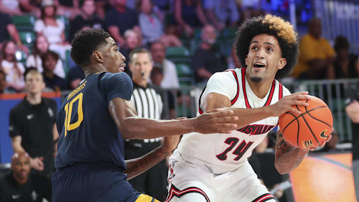Nov 28, 2024; Paradise Island, Bahamas, BHS;  Louisville Cardinals guard Chucky Hepburn (24) looks to shoot as West Virginia Mountaineers guard Sencire Harris (10) defends during the first half at Imperial Arena at the Atlantis resort. 