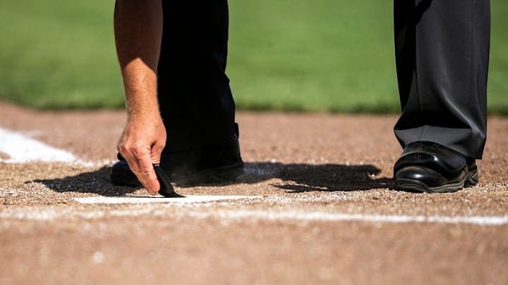 The home plate umpire clears the plate during the championship game of the Big Ten Baseball Tournament between Iowa and Maryland, Sunday, May 28, 2023, at Charles Schwab Field in Omaha, Neb.
