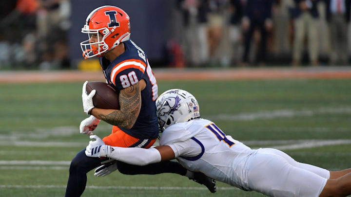 Aug 29, 2025; Champaign, Illinois, USA;  Illinois Fighting Illini wide receiver Hank Beatty (80) runs the ball after a pass reception as Western Illinois Leathernecks defensive back Buju Aumua-Tuisavura (14) tackles during the first half at Memorial Stadium. Mandatory Credit: Ron Johnson-Imagn Images