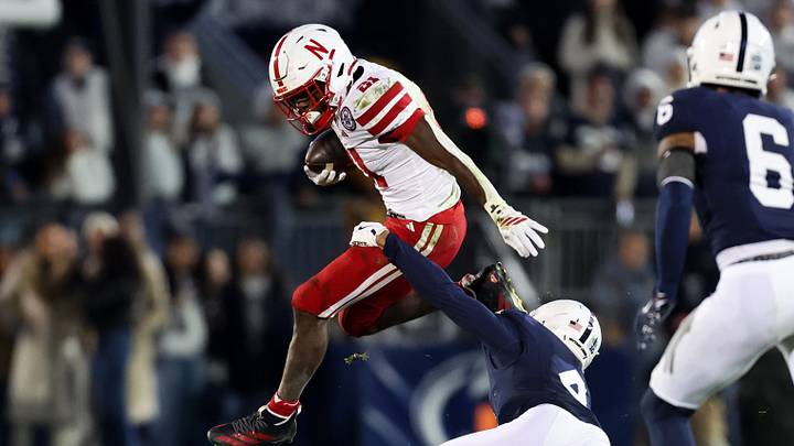 Nebraska Cornhuskers running back Emmett Johnson (21) jumps to avoid a tackle from Penn State Nittany Lions cornerback A.J. Harris (4) during the first quarter at Beaver Stadium. Nebraska Cornhuskers running back Emmett Johnson (21) jumps to avoid a tackle from Penn State Nittany Lions cornerback A.J. Harris (4) during the first quarter at Beaver Stadium.