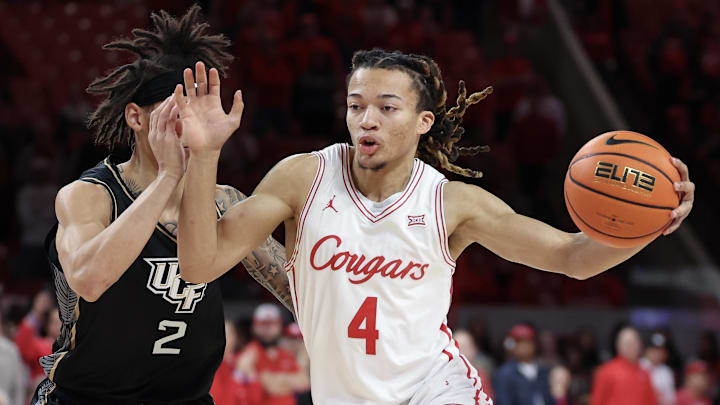 Feb 4, 2026; Houston, Texas, USA; Houston Cougars guard Kingston Flemings (4) drives against UCF Knights guard Riley Kugel (2) in the first half at Fertitta Center. Mandatory Credit: Thomas Shea-Imagn Images