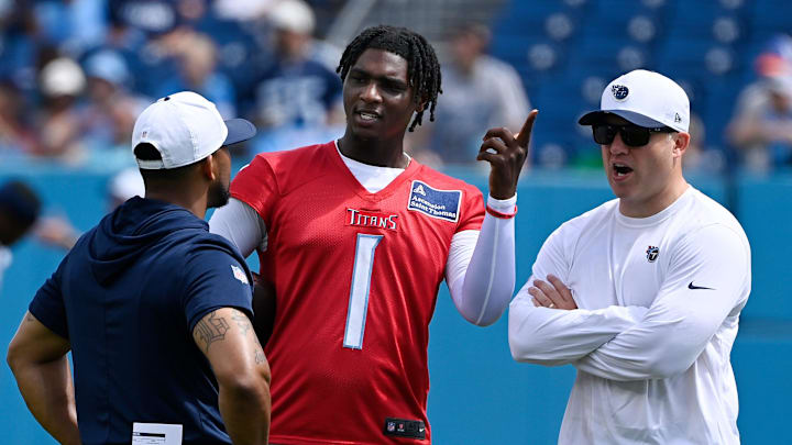 Tennessee Titans quarterback Cam Ward talks with coaches during “Back Together Weekend” training camp practice.