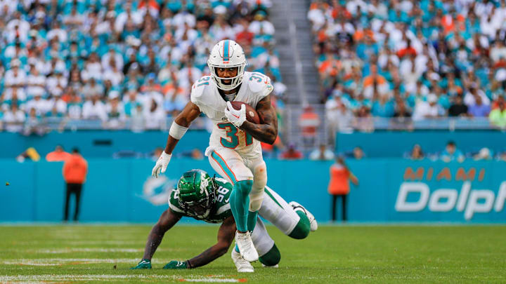 Dec 17, 2023; Miami Gardens, Florida, USA; Miami Dolphins running back Raheem Mostert (31) runs with the football ahead of New York Jets linebacker Quincy Williams (56) during the first quarter at Hard Rock Stadium. Mandatory Credit: Sam Navarro-Imagn Images