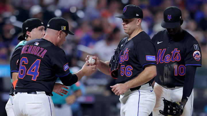 Aug 15, 2025; New York City, New York, USA; New York Mets manager Carlos Mendoza (64) takes the ball from relief pitcher Ryan Helsley (56) during a pitching change during the seventh inning against the Seattle Mariners at Citi Field. Mandatory Credit: Brad Penner-Imagn Images Aug 15, 2025; New York City, New York, USA; New York Mets manager Carlos Mendoza (64) takes the ball from relief pitcher Ryan Helsley (56) during a pitching change during the seventh inning against the Seattle Mariners at Citi Field. Mandatory Credit: Brad Penner-Imagn Images