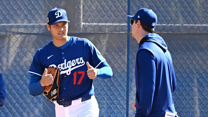 Feb 18, 2025; Glendale, AZ, USA;  Los Angeles Dodgers designated hitter Shohei Ohtani (17) works with Los Angeles Dodgers assistant pitching coach Connor McGuiness (87) during a spring training bullpen session at Camelback Ranch. Mandatory Credit: Jayne Kamin-Oncea-Imagn Images