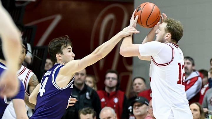 Northwestern Wildcats guard Angelo Ciaravino (44) hits Indiana Hoosiers forward Tucker DeVries (12) as he shoots a 3-pointer at Simon Skjodt Assembly Hall. 