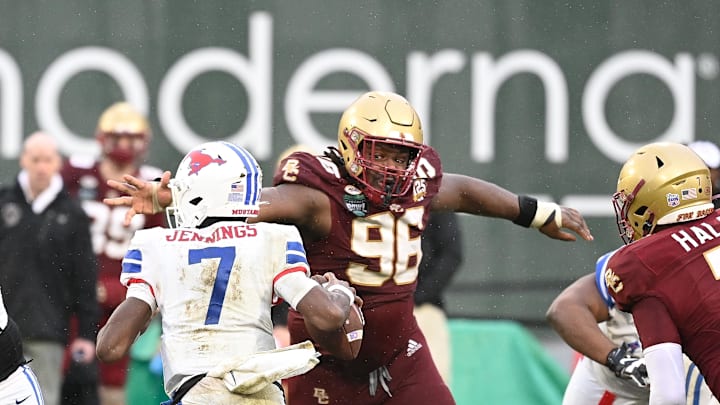 Dec 28, 2023; Boston, MA, USA; Boston College Eagles defensive tackle Cam Horsley (96) reaches out for Southern Methodist Mustangs quarterback Kevin Jennings (7) during the second half at Fenway Park. Mandatory Credit: Eric Canha-Imagn Images