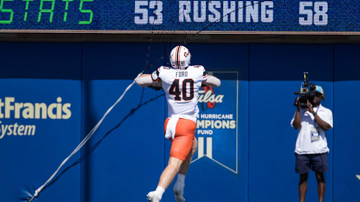 Sep 14, 2024; Tulsa, Oklahoma, USA; Oklahoma State Cowboys tight end Josh Ford (40) jumps as he runs into the end zone for a touchdown against the Tulsa Golden Hurricane during the second quarter at Skelly Field at H.A. Chapman Stadium. Mandatory Credit: Brett Rojo-Imagn Images Sep 14, 2024; Tulsa, Oklahoma, USA; Oklahoma State Cowboys tight end Josh Ford (40) jumps as he runs into the end zone for a touchdown against the Tulsa Golden Hurricane during the second quarter at Skelly Field at H.A. Chapman Stadium. Mandatory Credit: Brett Rojo-Imagn Images