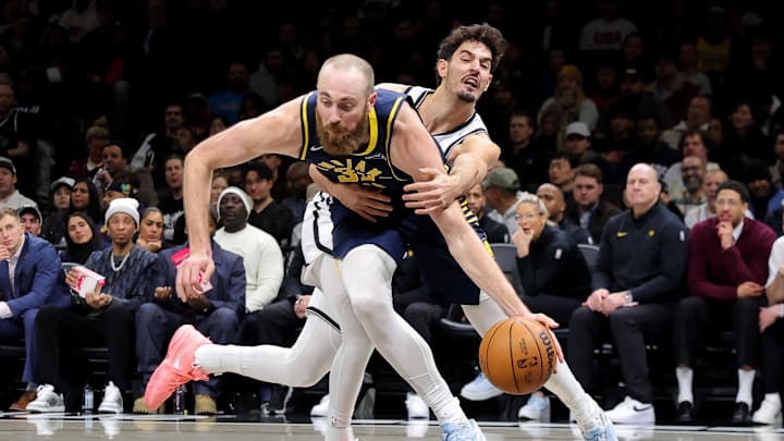 Feb 11, 2026; Brooklyn, New York, USA; Indiana Pacers center Jay Huff (32) is fouled by Brooklyn Nets guard Ben Saraf (77) during the fourth quarter at Barclays Center. Mandatory Credit: Brad Penner-Imagn Images