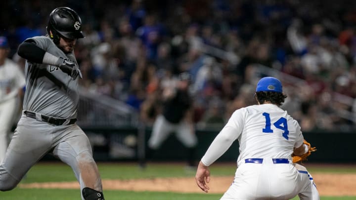 Gators' infielder Cade Fisher (3) with the throw to first for the out on Gamecocks catcher Cole Messina (19) Gators' infielder Cade Fisher (3) with the throw to first for the out on Gamecocks catcher Cole Messina (19)