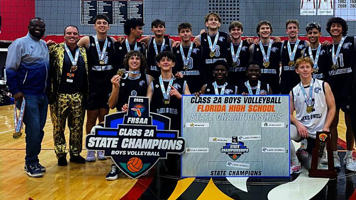 Lake Howell players, coaches and staff gather after winning the Class 2A boys volleyball state title Saturday at Polk State College.
