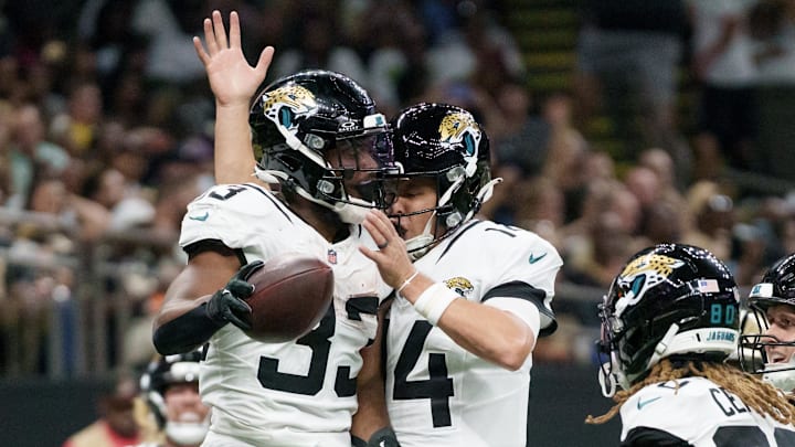 Aug 17, 2025; New Orleans, Louisiana, USA;  Jacksonville Jaguars running back Bhayshul Tuten (33) celebrates a touchdown with Jacksonville Jaguars quarterback Nick Mullens (14) during the first half against the New Orleans Saints at Caesars Superdome. Mandatory Credit: Matthew Hinton-Imagn Images