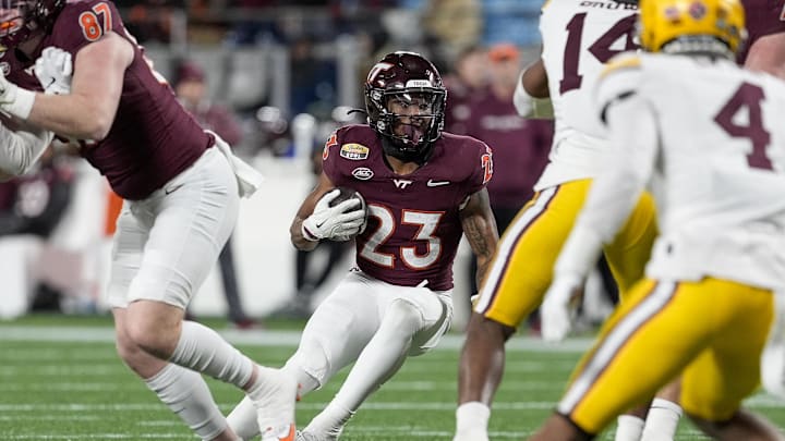 Jan 3, 2025; Charlotte, NC, USA; Virginia Tech Hokies running back Tyler Mason (23) makes a cut against the Minnesota Golden Gophers defense during the second half at the Duke’s Mayo Bowl at Bank of America Stadium. Mandatory Credit: Jim Dedmon-Imagn Images