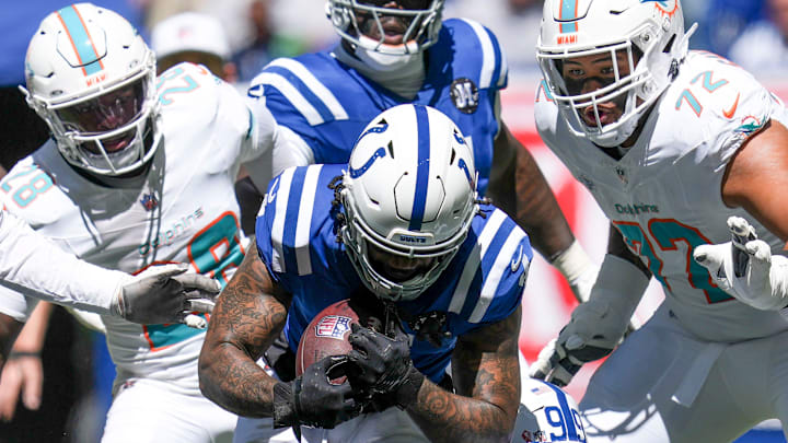 Miami Dolphins running back De'Von Achane (28) attempts to take down Indianapolis Colts cornerback Xavien Howard (4) after a fumble and turnover during the first half of a game against the Miami Dolphins on Sunday, Sept. 7, 2025, at Lucas Oil Stadium in Indianapolis.