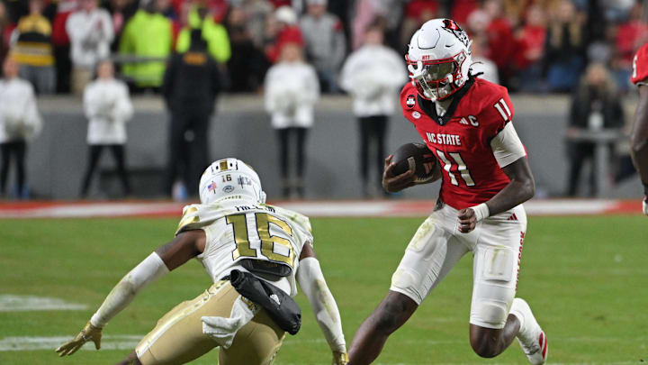 Nov 1, 2025; Raleigh, North Carolina, USA; North Carolina State Wolfpack quarter back CJ Bailey (11) runs the ball against Georgia Tech Yellow Jackets defensive back Kelvin Hill (16) during the fourth quarter at Carter-Finley Stadium. Mandatory Credit: Zachary Taft-Imagn Images Nov 1, 2025; Raleigh, North Carolina, USA; North Carolina State Wolfpack quarter back CJ Bailey (11) runs the ball against Georgia Tech Yellow Jackets defensive back Kelvin Hill (16) during the fourth quarter at Carter-Finley Stadium. Mandatory Credit: Zachary Taft-Imagn Images