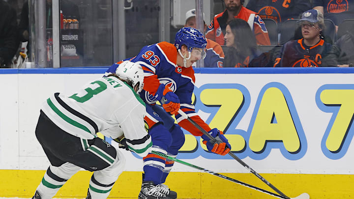 Edmonton Oilers forward Ryan Nugent-Hopkins (93) and Dallas Stars defensemen Chris Tanev (3) battle along the boards for a loose puck