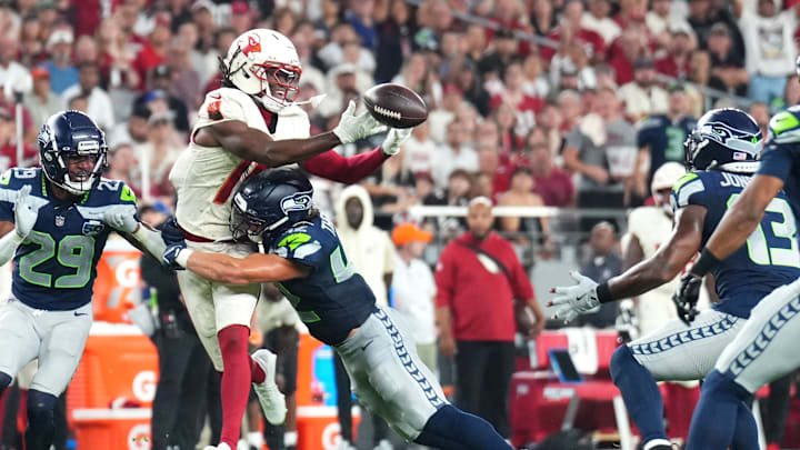Sep 25, 2025; Glendale, Arizona, USA;  Arizona Cardinals wide receiver Marvin Harrison Jr. (18) cannot make a catch against Seattle Seahawks linebacker Drake Thomas (42) as linebacker Ernest Jones IV (13) intercepts the ball in the second quarter at State Farm Stadium. Mandatory Credit: Joe Camporeale-Imagn Images