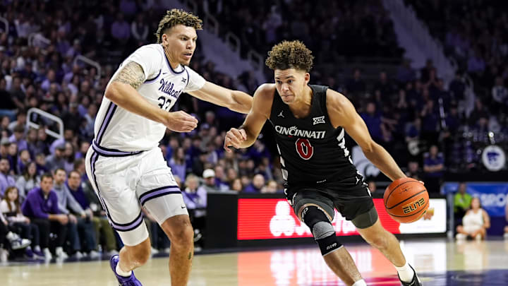 Dec 30, 2024; Manhattan, Kansas, USA; Cincinnati Bearcats guard Dan Skillings Jr. (0) drives against Kansas State Wildcats guard Coleman Hawkins (33) during the first half at Bramlage Coliseum. Mandatory Credit: Jay Biggerstaff-Imagn Images