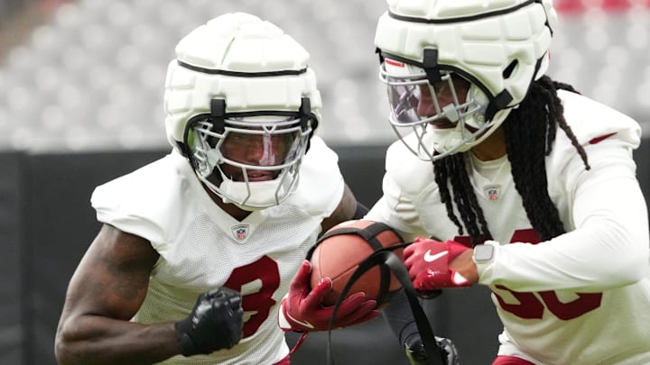 Arizona Cardinals safety Budda Baker (3) looks to punch the ball from the hands of teammate Andre Chachere (36) during the team's training camp session at State Farm Stadium in Glendale on July 24, 2024. Arizona Cardinals safety Budda Baker (3) looks to punch the ball from the hands of teammate Andre Chachere (36) during the team's training camp session at State Farm Stadium in Glendale on July 24, 2024.