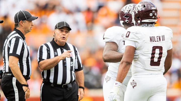 A referee warns Texas A&M defensive lineman Walter Nolen (0) during a football game between