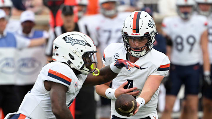 Nov 15, 2025; Durham, North Carolina, USA; Virginia Cavaliers quarter back Chandler Morris (4) hands the ball to Virginia Cavaliers running back J'Mari Taylor (3) during the first quarter against the Duke Blue Devils at Wallace Wade Stadium. Mandatory Credit: Zachary Taft-Imagn Images Nov 15, 2025; Durham, North Carolina, USA; Virginia Cavaliers quarter back Chandler Morris (4) hands the ball to Virginia Cavaliers running back J'Mari Taylor (3) during the first quarter against the Duke Blue Devils at Wallace Wade Stadium. Mandatory Credit: Zachary Taft-Imagn Images