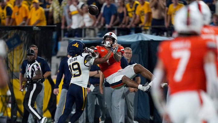 Sep 19, 2026; Charlotte, North Carolina, USA; Virginia Cavaliers receiver Rico Flores (1) is upended by West Virginia Mountaineers cornerback Nick Taylor (19) during the second half at Bank of America Stadium. Mandatory Credit: Jim Dedmon-Imagn Images Sep 19, 2026; Charlotte, North Carolina, USA; Virginia Cavaliers receiver Rico Flores (1) is upended by West Virginia Mountaineers cornerback Nick Taylor (19) during the second half at Bank of America Stadium. Mandatory Credit: Jim Dedmon-Imagn Images