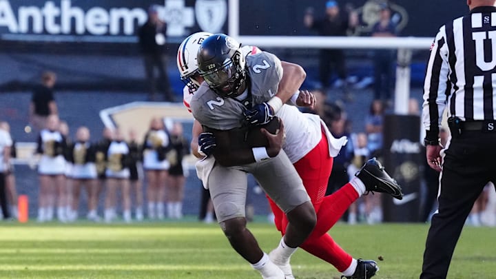 Nov 11, 2023; Boulder, Colorado, USA; Arizona Wildcats linebacker Dominic Lolesio (42) tackles Colorado Buffaloes quarterback Shedeur Sanders (2) in the second half at Folsom Field. Mandatory Credit: Ron Chenoy-Imagn Images