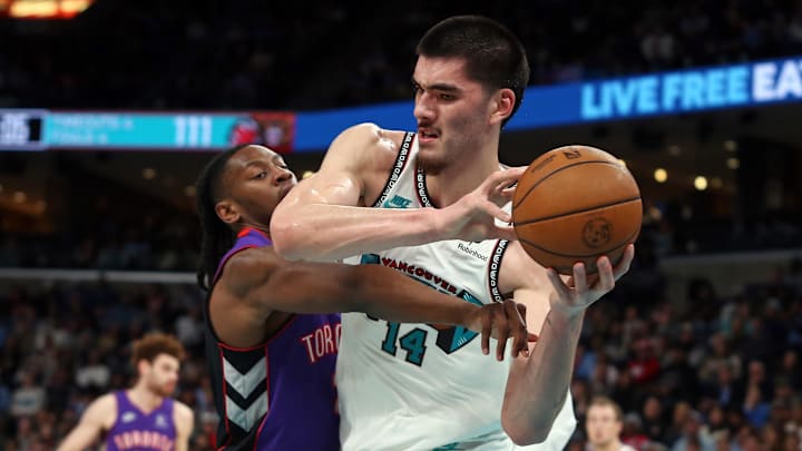 Dec 26, 2024; Memphis, Tennessee, USA; Memphis Grizzlies center Zach Edey (14) and Toronto Raptors forward Jonathan Mogbo (2) battle for a rebound during the third quarter at FedExForum. Mandatory Credit: Petre Thomas-Imagn Images