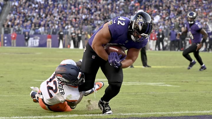 Nov 3, 2024; Baltimore, Maryland, USA;  Baltimore Ravens fullback Patrick Ricard (42) dives through Denver Broncos linebacker Kwon Alexander (12) tackle attempt for a touchdown  during the second half at M&T Bank Stadium. Mandatory Credit: Tommy Gilligan-Imagn Images