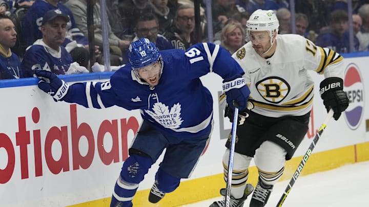 Apr 24, 2024; Toronto, Ontario, CAN; Toronto Maple Leafs forward Calle Jarnkrok (19) and Boston Bruins defenseman Kevin Shattenkirk (12) battle to get to the puck during the first period of game three of the first round of the 2024 Stanley Cup Playoffs at Scotiabank Arena. Mandatory Credit: John E. Sokolowski-Imagn Images