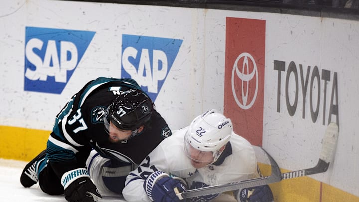 Mar 27, 2025; San Jose, California, USA; San Jose Sharks defenseman Timothy Liljegren (37) and Toronto Maple Leafs defenseman Jake McCabe (22) on the ice after a check during the third period at SAP Center at San Jose. Mandatory Credit: D. Ross Cameron-Imagn Images