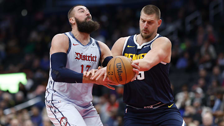 Dec 7, 2024; Washington, District of Columbia, USA; Washington Wizards center Jonas Valanciunas (17) is fouled while driving to the basket by Denver Nuggets center Nikola Jokic (15) in the third quarter at Capital One Arena. Mandatory Credit: Geoff Burke-Imagn Images