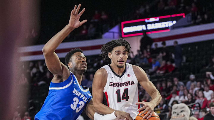 Dec 19, 2024; Athens, Georgia, USA; Georgia Bulldogs forward Asa Newell (14) tries to maintain possession of the ball against Buffalo Bulls center Tim Oboh (33) during the first half at Stegeman Coliseum. Mandatory Credit: Dale Zanine-Imagn Images