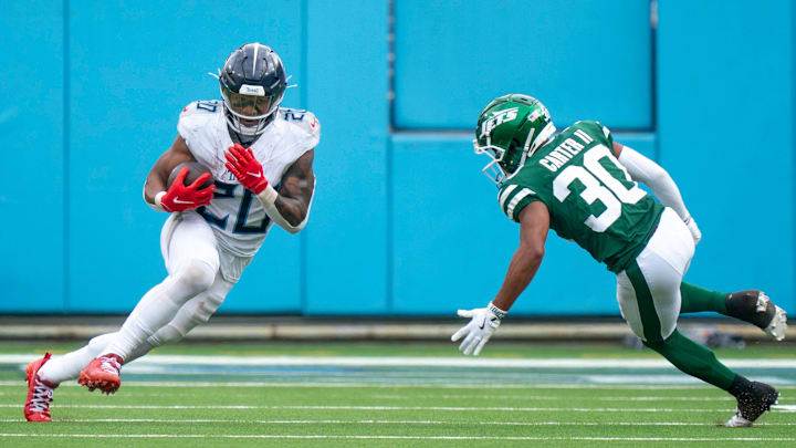 Tennessee Titans running back Tony Pollard runs after a catch while guarded by New York Jets cornerback Michael Carter II.