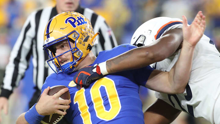 Nov 9, 2024; Pittsburgh, Pennsylvania, USA; Pittsburgh Panthers quarterback Eli Holstein (10) is tackled by Virginia Cavaliers defensive tackle Terrell Jones (25) during the second quarter at Acrisure Stadium. Nov 9, 2024; Pittsburgh, Pennsylvania, USA; Pittsburgh Panthers quarterback Eli Holstein (10) is tackled by Virginia Cavaliers defensive tackle Terrell Jones (25) during the second quarter at Acrisure Stadium.