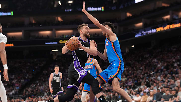 Mar 25, 2025; Sacramento, California, USA; Sacramento Kings center Domantas Sabonis (11) drives to the hoop next to Oklahoma City Thunder center Chet Holmgren (7) in the second quarter at the Golden 1 Center. Mandatory Credit: Cary Edmondson-Imagn Images