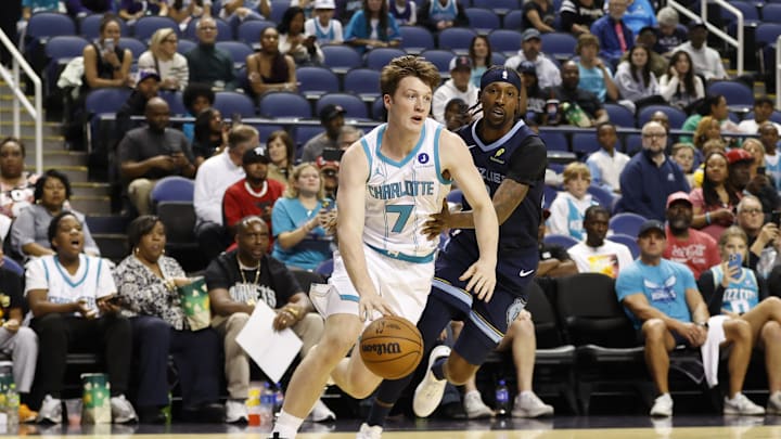 Oct 15, 2025; Greensboro, North Carolina, USA; Charlotte Hornets guard/forward Kon Knueppel (7) drives past Memphis Grizzlies guard Kentavious Caldwell-Pope (3) during first quarter action at First Horizon Coliseum. Mandatory Credit: Brian Westerholt-Imagn Images