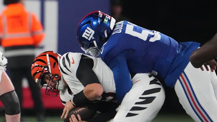 Oct 13, 2024; East Rutherford, New Jersey, USA;  New York Giants linebacker Azeez Ojulari (51) tackles Cincinnati Bengals quarterback Joe Burrow (9) during the first half at MetLife Stadium. Mandatory Credit: Robert Deutsch-Imagn Images