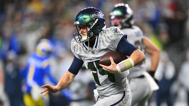 Dec 18, 2025; Seattle, Washington, USA; Seattle Seahawks quarterback Sam Darnold (14) runs against the Los Angeles Rams in the first half at Lumen Field.