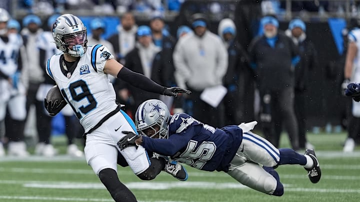Dec 15, 2024; Charlotte, North Carolina, USA; Carolina Panthers wide receiver Adam Thielen (19) is tackled by Dallas Cowboys cornerback Andrew Booth Jr. (25) during the second half at Bank of America Stadium. Mandatory Credit: Jim Dedmon-Imagn Images