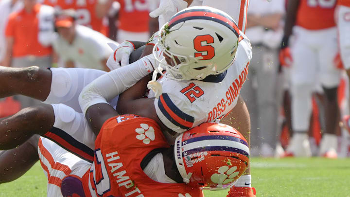 Sep 20, 2025; Clemson, South Carolina, USA; Syracuse Orange receiver Justus Ross-Simmons (12) is tackled by Clemson Tigers cornerback Ashton Hampton (23) during the first quarter at Memorial Stadium. Mandatory Credit: Ken Ruinard/GREENVILLE NEWS-USA TODAY Network via Imagn Images