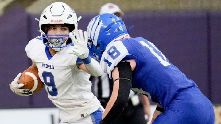 Gladbrook-Reinbeck’s Treyvon Herron (9) stiff arms Remsen St. Mary's Braxton Kneip (18) while carrying the ball during the Iowa high school 8-player championship Thursday, Nov. 21, 2024 at the UNI-Dome in Cedar Falls, Iowa.