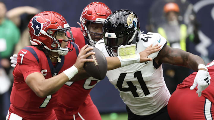 Nov 26, 2023; Houston, Texas, USA; Houston Texans quarterback C.J. Stroud (7) scrambles from Jacksonville Jaguars linebacker Josh Allen (41) in the first quarter at NRG Stadium. Mandatory Credit: Thomas Shea-Imagn Images