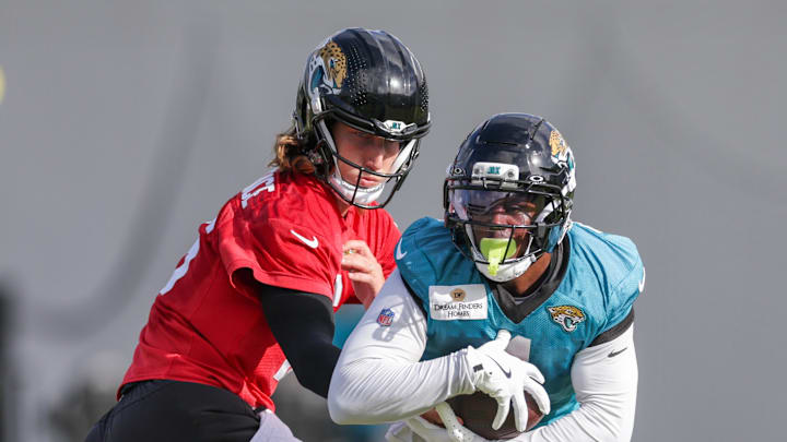 Jul 25, 2025; Jacksonville, FL, USA; Jacksonville Jaguars quarterback Trevor Lawrence (16) and running back Travis Etienne Jr. (1) participate in training camp at Miller Electric Center. Mandatory Credit: Nathan Ray Seebeck-Imagn Images