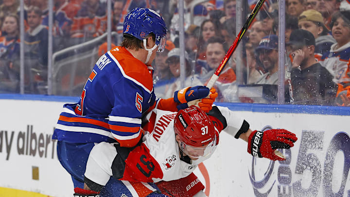 Mar 6, 2026; Edmonton, Alberta, CAN; Edmonton Oilers defensemen Connor Murphy (5) battles for the puck against Carolina Hurricanes forward Andrei Svechnikov (37) during the second period at Rogers Place. Mandatory Credit: Perry Nelson-Imagn Images