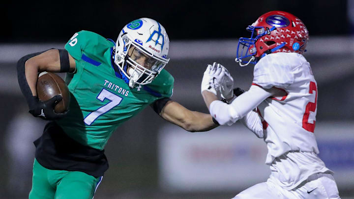 Green Bay Notre Dame's Kingston Allen (7) stiff-arms Slinger High School's Ethan Fisher (23) during a WIAA Division 2 second round playoff game on Friday, October 31, 2025, at Notre Dame Academy in Green Bay, Wis. Notre Dame won the game, 56-42.