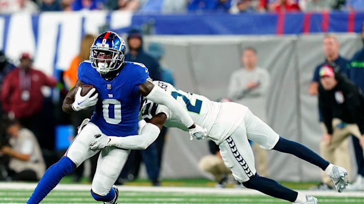 New York Giants wide receiver Parris Campbell (0) is tackled by Seattle Seahawks cornerback Devon Witherspoon (21) in 2023
