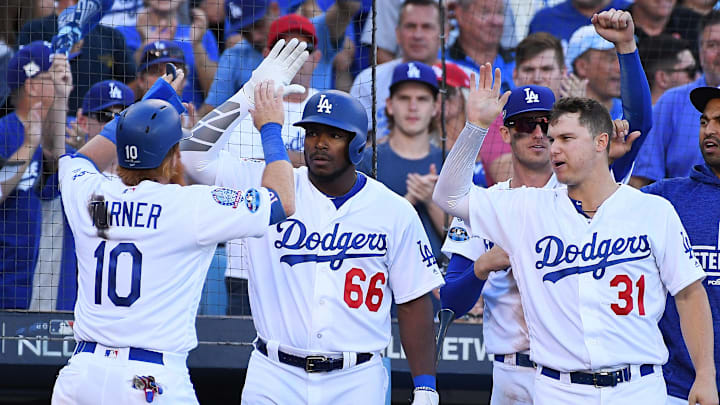 Oct 17, 2018; Los Angeles, CA, USA; Los Angeles Dodgers third baseman Justin Turner (10) celebrates with right fielder Yasiel Puig (66) and left fielder Joc Pederson (31) after scoring on a single by first baseman Max Muncy (13) the sixth inning in game five of the 2018 NLCS playoff baseball series at Dodger Stadium. 